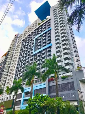 a tall building with palm trees in front of it at Manhattan Heights Tower-D Staycation in Metro Manila in Manila