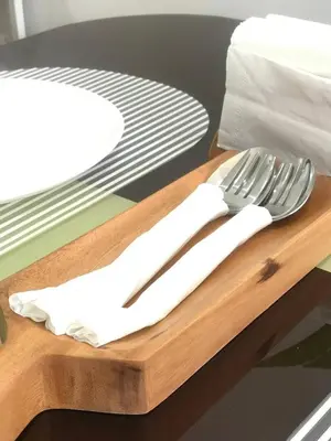 a knife and fork on a wooden cutting board at Manhattan Heights Tower-D Staycation in Metro Manila in Manila