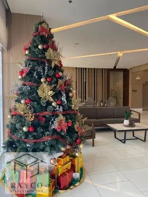 a christmas tree with presents under it in a lobby at Condo with Sunset View in Manila