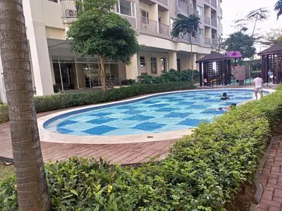 a large swimming pool in front of a building at Condo with Sunset View in Manila