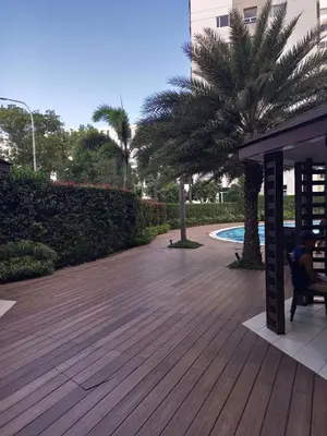 a person sitting on a bench on a wooden deck at Condo with Sunset View in Manila