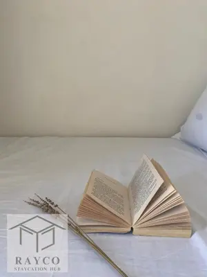 an open book on a bed with two chop sticks at Condo with Sunset View in Manila