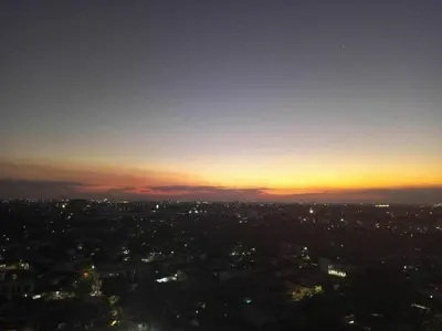 a view of a city at night with the sun setting at Cozy Escape with Golden Hour View Condo in Manila