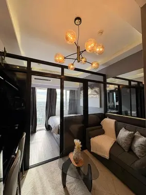 a living room with a couch and a chandelier at Cozy Escape with Golden Hour View Condo in Manila