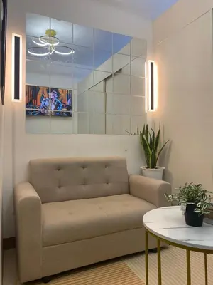 a living room with a couch and a table at Stunning Pool and City View in Manila