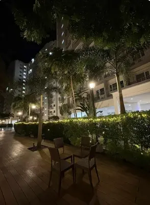 a table and chairs on a patio at night at Stunning Pool and City View in Manila