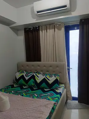 a bed in a room with a window and a window at Sea Residences Golden escape condotel in Manila
