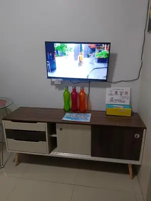 a tv sitting on top of a table with vases at Sea Residences Golden escape condotel in Manila