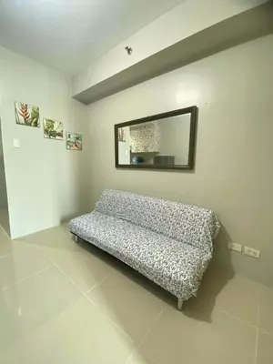 a bed in a room with a mirror on the wall at Sea Residences Golden escape condotel in Manila