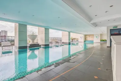 a large swimming pool in a building with water at Admiral Baysuites 2602 in Manila