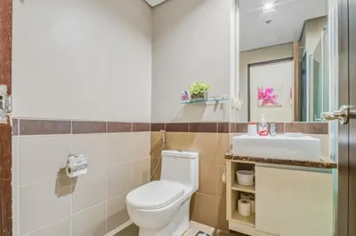 a bathroom with a toilet and a sink at Admiral Baysuites 2602 in Manila