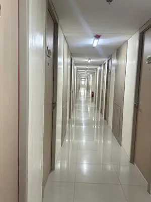 an empty hallway of a building with white floors and walls at UDCT Condo Hotel in Manila in Manila