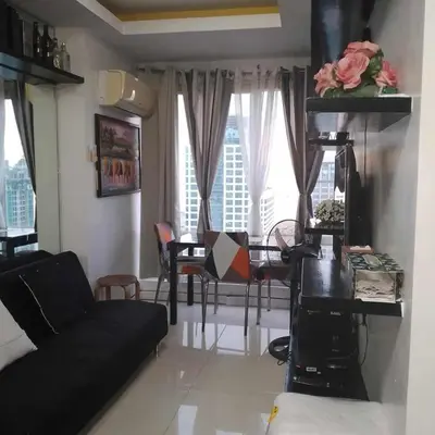 a living room with a black couch and a table at Manila Skyview suite at Birch tower condo in Manila