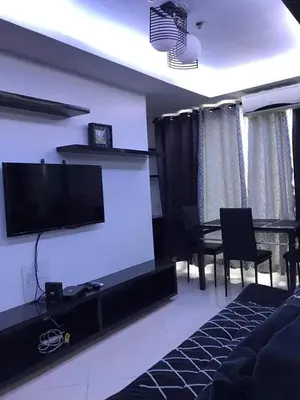 a living room with a television and a dining table at Manila Skyview suite at Birch tower condo in Manila