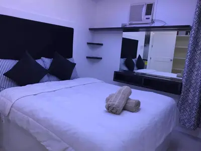 a white bed with a stuffed animal on top of it at Manila Skyview suite at Birch tower condo in Manila