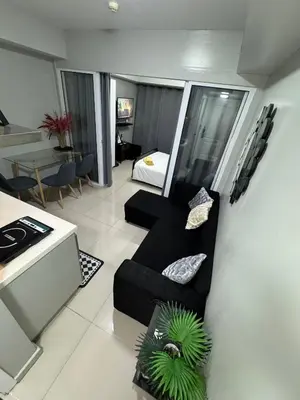 a living room with a couch and a bed at Casa Est Staycation - Azure Urban Resort Residences in Manila