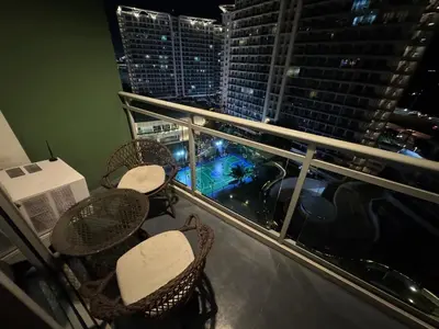 a balcony with tables and chairs on a building at Casa Est Staycation - Azure Urban Resort Residences in Manila