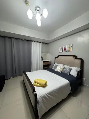 a bedroom with a large bed with a yellow blanket on it at Casa Est Staycation - Azure Urban Resort Residences in Manila