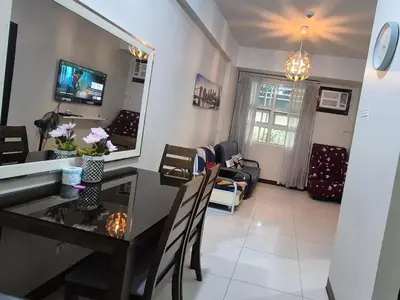 a dining room and living room with a table and chairs at A&G Condotel Right Across NAIA Terminal 3 in Manila