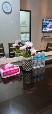 a counter with several bottles of water and flowers at A&G Condotel Right Across NAIA Terminal 3 in Manila