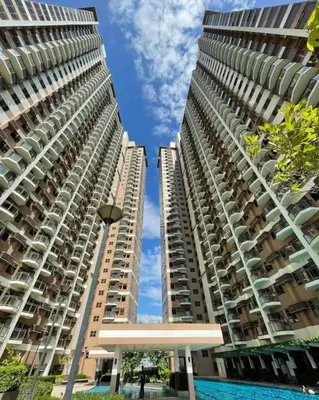 two tall apartment buildings with a pool in between them at Affordable 1BR Condo In Pasay with Balcony and Amenity View, Free Pool Fast WiFi Near NAIA Airport , MOA,PICC in Manila