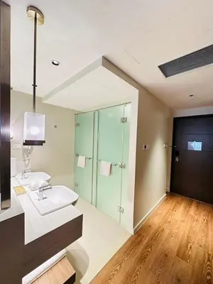 a bathroom with a sink and a glass shower at Hotel Residence Acqua - Novotel Suites in Manila