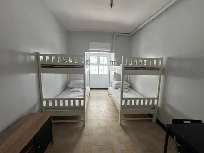 a room with three bunk beds and a table at Just for sleeps in Manila