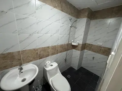 a bathroom with a toilet and a sink at Just for sleeps in Manila