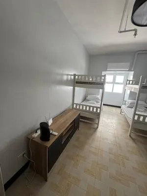 a room with two bunk beds and a table at Just for sleeps in Manila