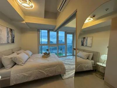 a bedroom with a bed and a view of the ocean at 35th Prime Staycation BGC in Manila