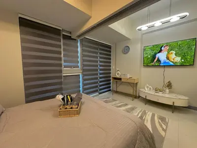 a bedroom with a bed and a tv on the wall at 35th Prime Staycation BGC in Manila