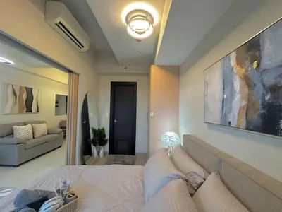 a bedroom with a bed and a large painting on the wall at 35th Prime Staycation BGC in Manila