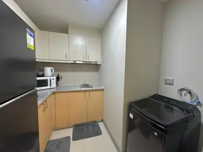 a small kitchen with a refrigerator and a dishwasher at 35th Prime Staycation BGC in Manila