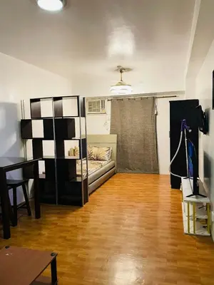 a living room with a couch and a bed in a room at Cozy Transient Home Uno in Manila