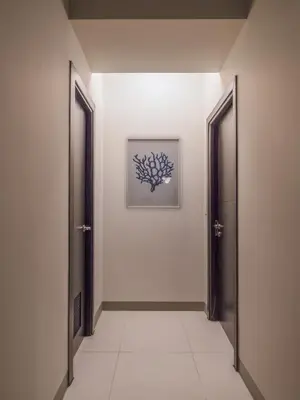 a hallway with two doors and a picture on the wall at Modern 2-Bedroom BGC Condo by Uptown Mall in Manila