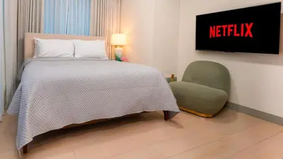 a bedroom with a bed and a green chair at Modern 2-Bedroom BGC Condo by Uptown Mall in Manila