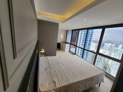a bedroom with a bed and a large window at Staycation by Carmen Romualdo in Manila
