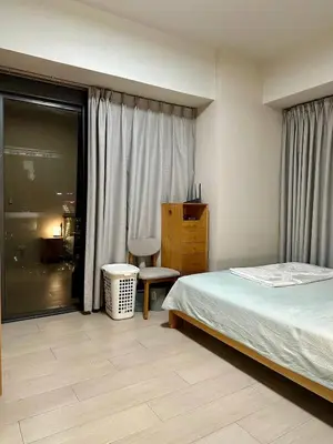 a bedroom with a bed and a chair and a window at Condotels by ZJM Residence in Manila
