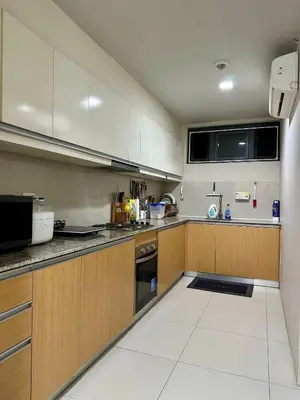 a large kitchen with wooden cabinets and appliances at Condotels by ZJM Residence in Manila