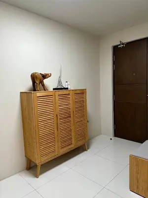 a room with a wooden cabinet with a dog statue on it at Condotels by ZJM Residence in Manila