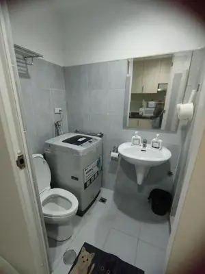 a bathroom with a toilet and a sink at Sea Residences Pasay City MOA by Jhayem in Manila