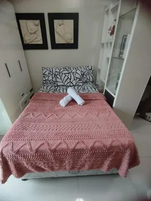 a bedroom with a bed with a red comforter at Sea Residences Pasay City MOA by Jhayem in Manila