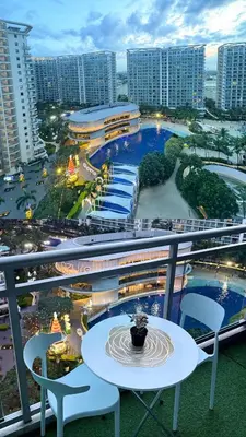 a balcony with a table and chairs and buildings at Azure Urban Resort Residences in Manila
