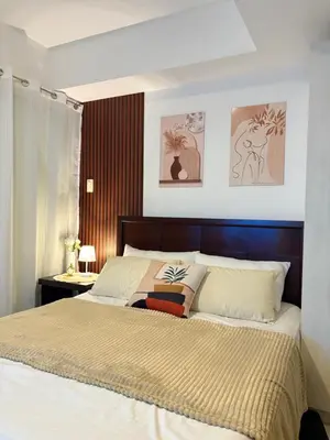 a bedroom with a large bed with a wooden headboard at Azure Urban Resort Residences in Manila