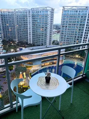 a table and chairs on a balcony with buildings at Azure Urban Resort Residences in Manila