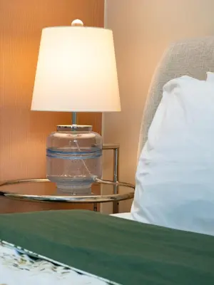 a lamp on a table next to a bed at Uptown Parksuites Balcony Mall View in Manila