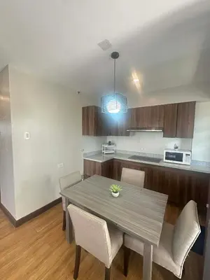 a kitchen with a table and chairs in a room at Exquisite Property Stays at Acacia Estate Taguig City in Manila