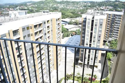 an apartment balcony with a view of buildings at The Cube at 15th in Taytay