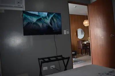 a flat screen tv on the wall of a bedroom at The Cube at 15th in Taytay