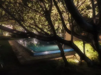 a pool in a garden with a tree at The Cube at 15th in Taytay